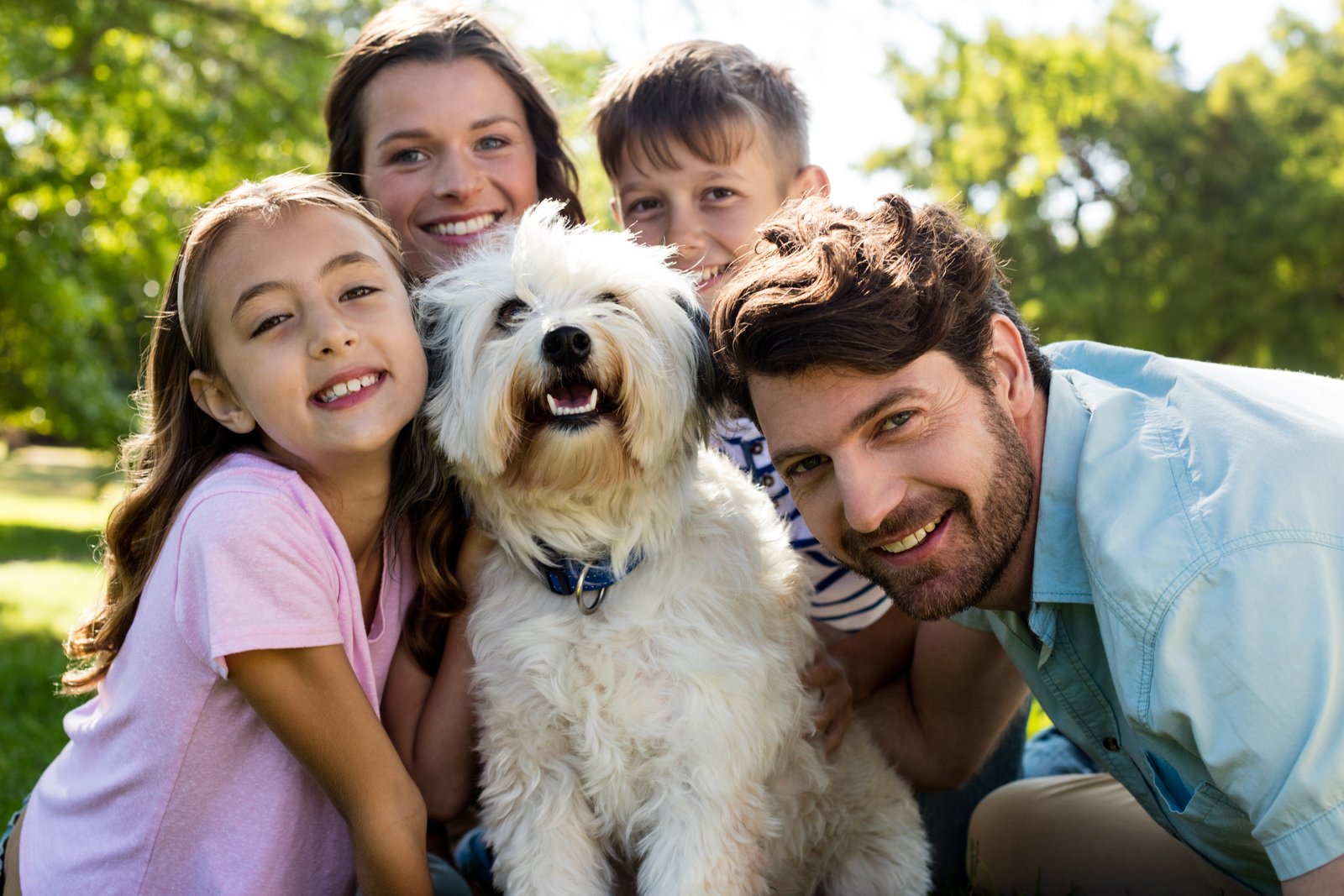Familia con su perro sonriendo